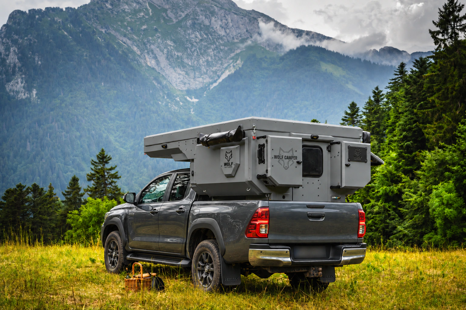Toyota Hilux in anthracite grey with WOLF CAMPER in Mineral grey, solid cabinets — Rear left three-quarter, Roof closed, Black laser engraving.