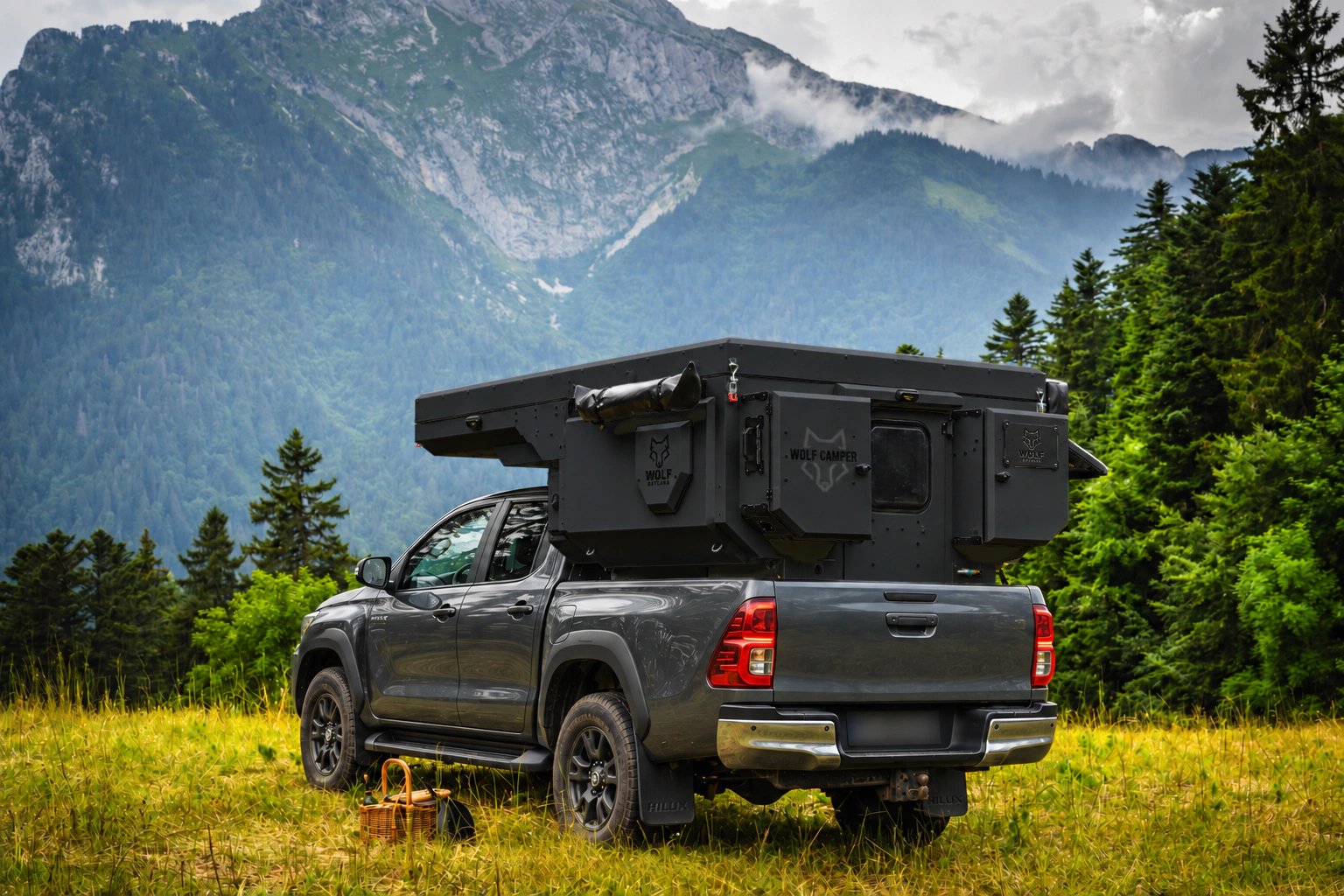 Toyota Hilux in anthracite grey with WOLF CAMPER in Matt black, solid cabinets — Rear left three-quarter, Roof closed, Black laser engraving.