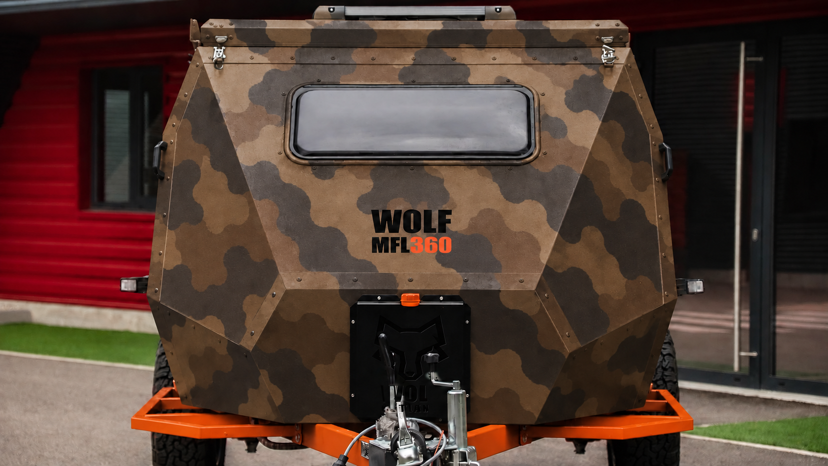 Front view of WOLF MFL 360 caravan in dark desert camouflage, roof closed.