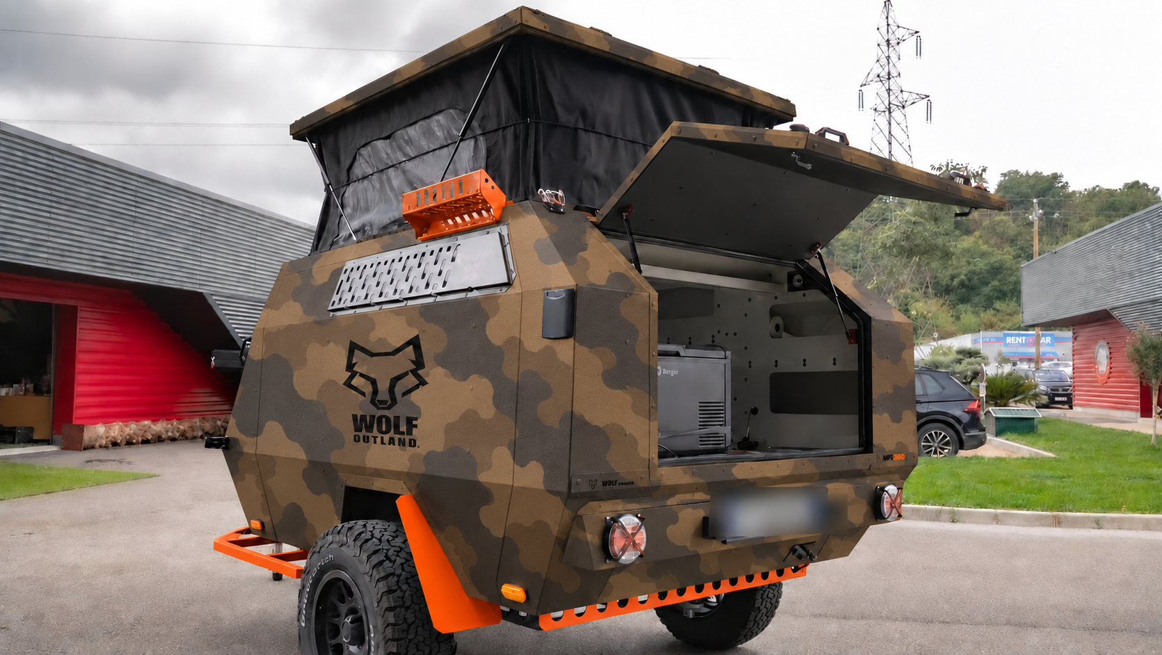 Rear three-quarter view · left side of WOLF MFL 360 caravan in dark desert camouflage, roof raised · kitchen open.