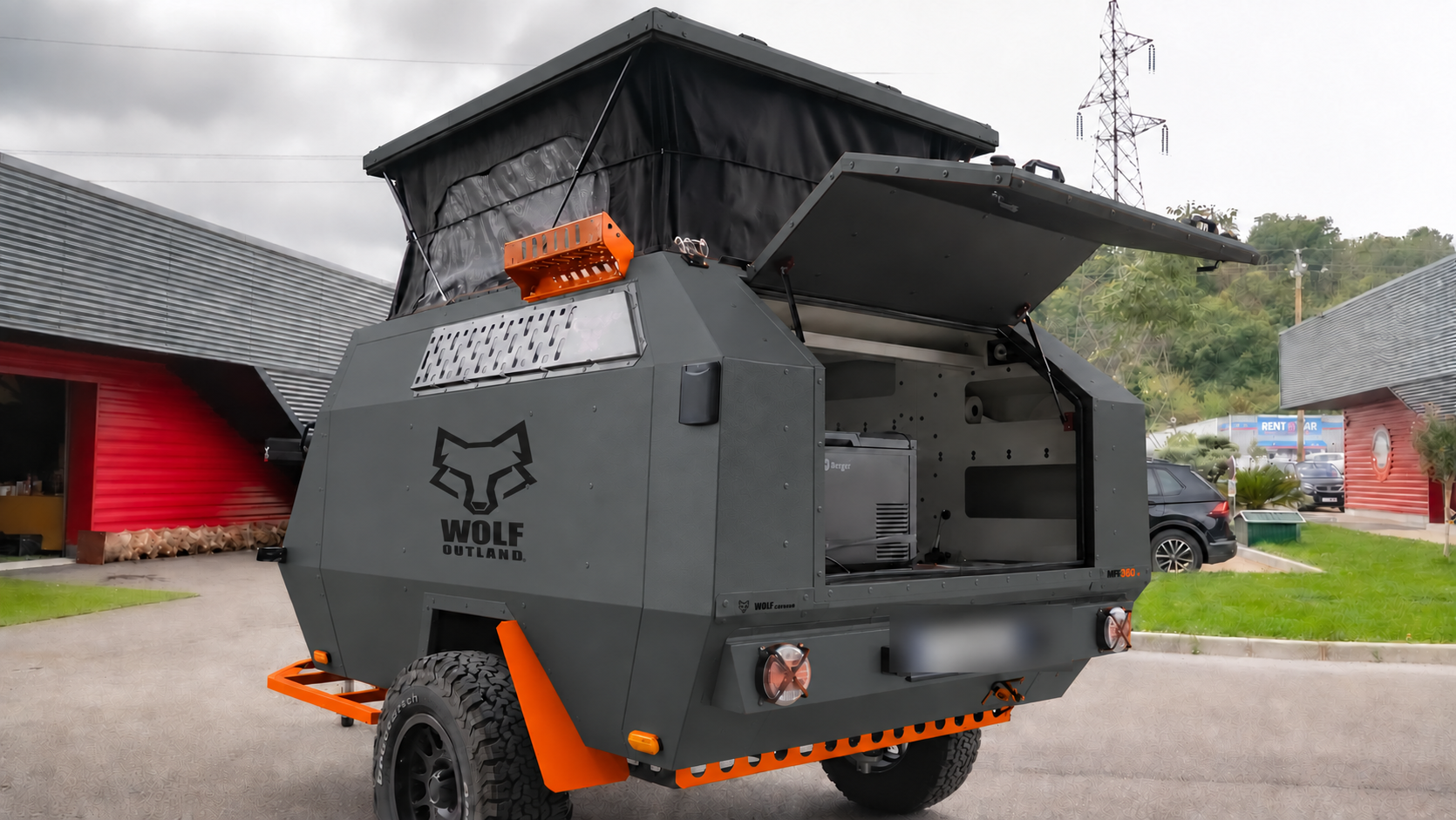 Rear three-quarter view · left side of WOLF MFL 360 caravan in graphite, roof raised · kitchen open.