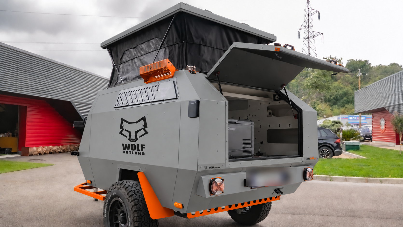 Rear three-quarter view · left side of WOLF MFL 360 caravan in mineral grey, roof raised · kitchen open.