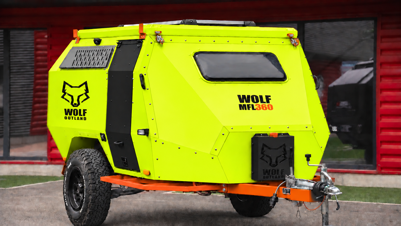 Front three-quarter view · right side of WOLF MFL 360 caravan in fluorescent yellow, roof closed · door closed. Front three-quarter view · right side of WOLF MFL 360 caravan in fluorescent yellow, roof closed · door closed.
