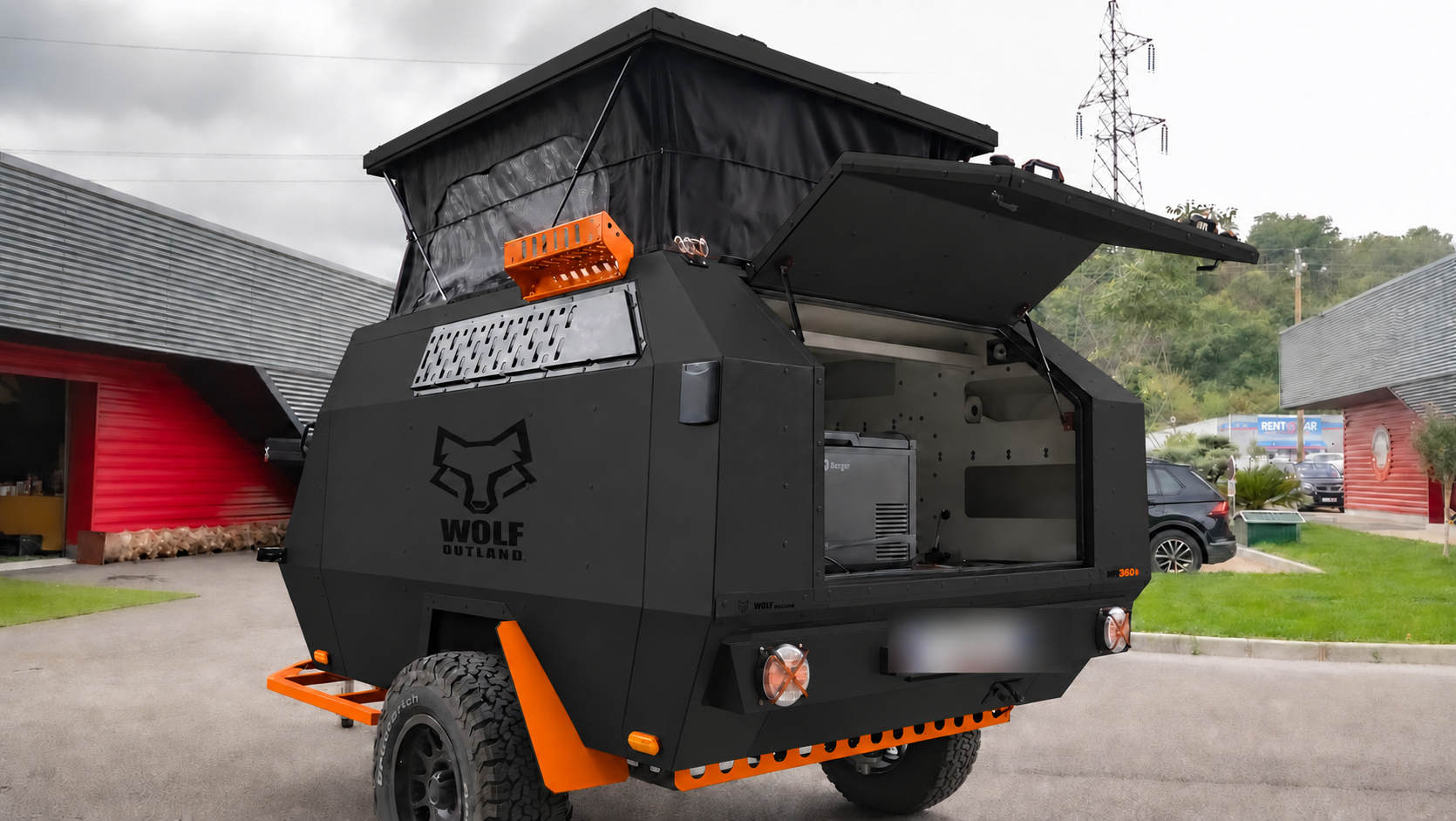 Rear three-quarter view · left side of WOLF MFL 360 caravan in matt black, roof raised · kitchen open.