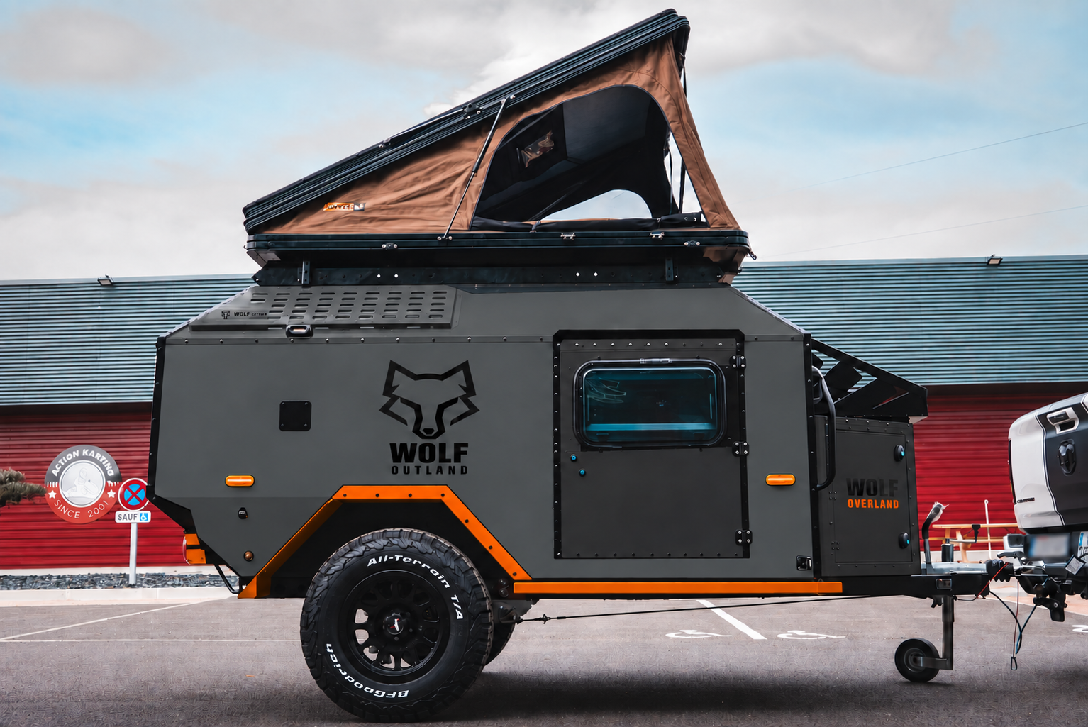 Side view of WOLF Overland caravan in graphite, tent raised · doors closed. Side view of WOLF Overland caravan in graphite, tent raised · doors closed.