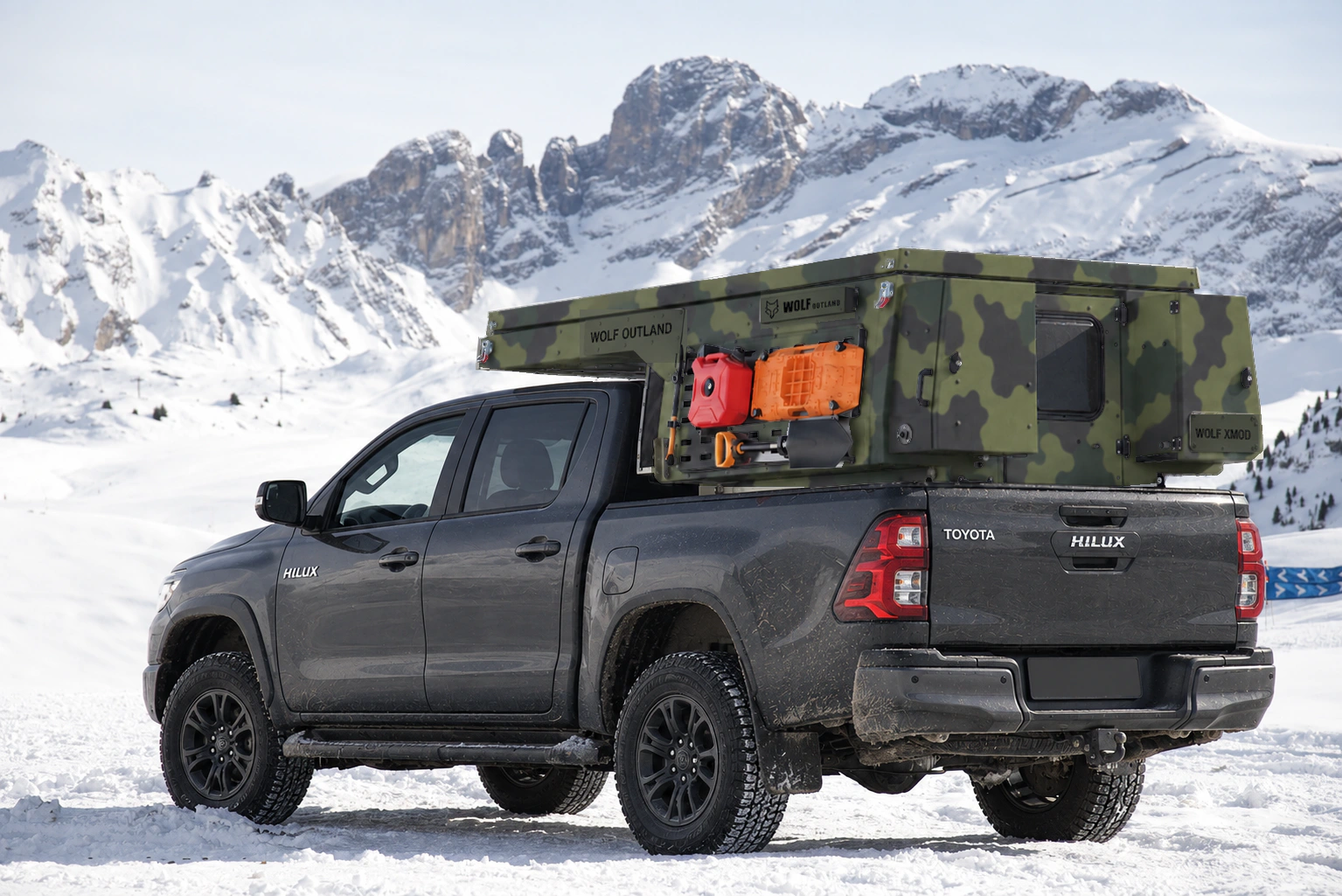Toyota Hilux in anthracite grey with WOLF XMOD in Army camouflage, two solid rear cabinets — Rear left three-quarter view, roof closed, Black engravings.