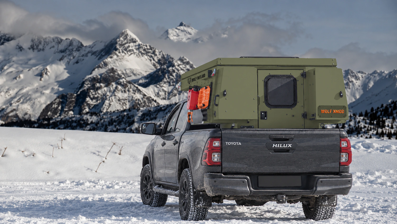 Toyota Hilux in anthracite grey with WOLF XMOD in Tactical olive, two solid rear cabinets — Rear view, roof closed, Orange backlit WOLF XMOD plate.