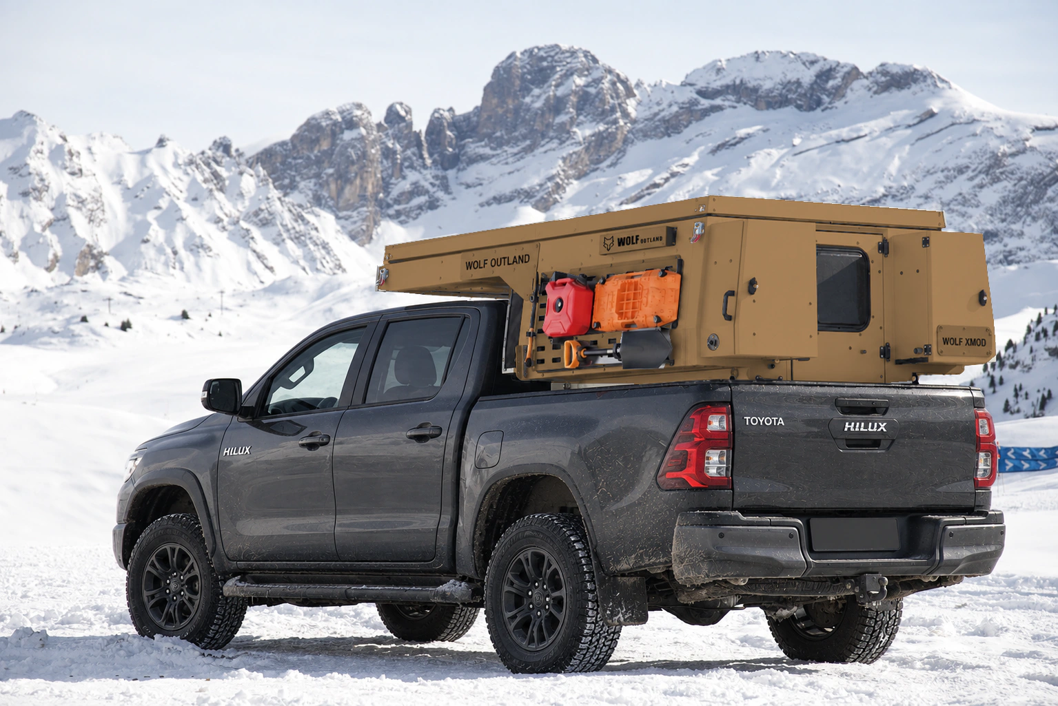 Toyota Hilux in anthracite grey with WOLF XMOD in Bronze, two solid rear cabinets — Rear left three-quarter view, roof closed, Black engravings.